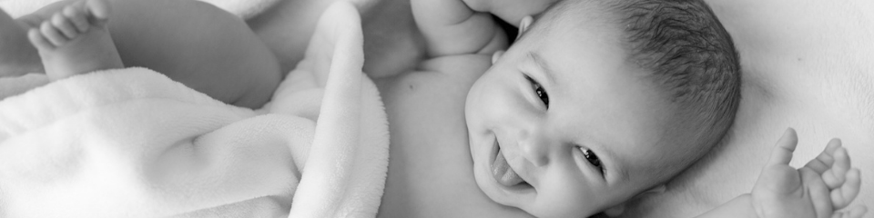 Smiling infant snuggled in a blanket