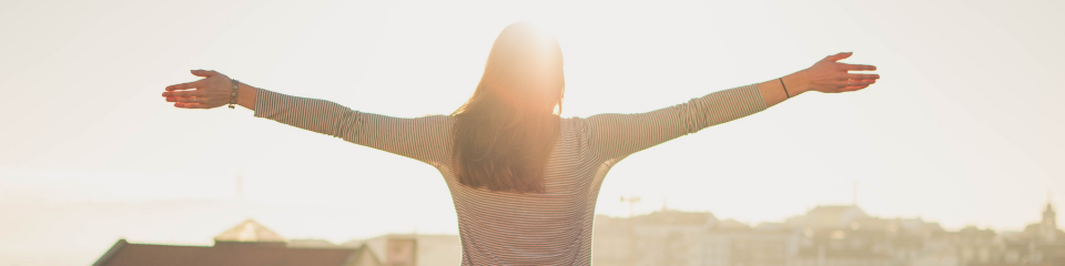 Woman embracing the sunshine with arms wide open